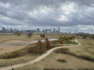 view from a pedestrian bridge of a large park with trails